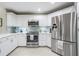 Bright kitchen with white cabinets, stainless steel appliances, and a stylish backsplash complemented by modern fixtures at 423 Fan Palm Ne Ct, St Petersburg, FL 33703