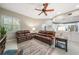 Comfortable living room featuring plush seating, a ceiling fan, and seamless transition into the adjacent kitchen area at 423 Fan Palm Ne Ct, St Petersburg, FL 33703