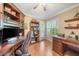 This home office features a ceiling fan, built-in bookshelves, and a desk at 423 Fan Palm Ne Ct, St Petersburg, FL 33703