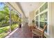 Covered patio featuring brick flooring, a small table and seating, with views of landscaped backyard at 423 Fan Palm Ne Ct, St Petersburg, FL 33703