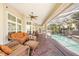 Relaxing screened-in lanai featuring wicker furniture and scenic views of the swimming pool at 423 Fan Palm Ne Ct, St Petersburg, FL 33703
