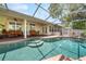 Screened-in pool with lounge seating and hot tub on the brick pool deck at 423 Fan Palm Ne Ct, St Petersburg, FL 33703