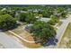 Aerial view showing a home, mature trees, surrounding neighborhood, and well-maintained landscaping at 4608 Deltona Blvd, Spring Hill, FL 34606