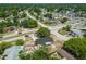 Aerial view showcases the home's setting amidst lush trees and convenient access to nearby roads and neighborhood amenities at 4608 Deltona Blvd, Spring Hill, FL 34606