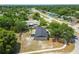 Aerial view of home with a screened porch, mature trees, and proximity to a main road at 4608 Deltona Blvd, Spring Hill, FL 34606