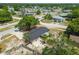An aerial perspective reveals a home with a screened patio, lush trees, and an inviting backyard in a neighborhood setting at 4608 Deltona Blvd, Spring Hill, FL 34606