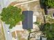 A clear aerial shot shows the house with its dark roof, surrounded by trees, a road, and a small fenced-in backyard at 4608 Deltona Blvd, Spring Hill, FL 34606