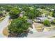 Aerial view showcases a home nestled among mature trees, surrounded by lush greenery at 4608 Deltona Blvd, Spring Hill, FL 34606