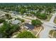 An aerial view of this home shows mature trees, nearby houses, and neighborhood street access at 4608 Deltona Blvd, Spring Hill, FL 34606