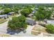 Aerial view of a home with mature trees, a fenced backyard, and a paved driveway at 4608 Deltona Blvd, Spring Hill, FL 34606
