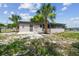 View of the home's backyard, featuring a screened-in porch and lush greenery at 4608 Deltona Blvd, Spring Hill, FL 34606