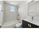 Bright bathroom featuring a sleek vanity with gold hardware and tiled shower at 4608 Deltona Blvd, Spring Hill, FL 34606