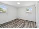 Bright bedroom with wood-look floors, two windows, and ample closet space at 4608 Deltona Blvd, Spring Hill, FL 34606