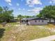 Rear exterior view of the home with a fenced backyard, screened porch, and well-maintained landscaping at 4608 Deltona Blvd, Spring Hill, FL 34606