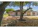 Inviting single-level house boasting stone details and mature trees, creating a warm and welcoming atmosphere at 4608 Deltona Blvd, Spring Hill, FL 34606