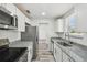 Modern kitchen features granite countertops, white cabinetry and stainless appliances at 4608 Deltona Blvd, Spring Hill, FL 34606