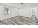 Bright living room featuring wood-look floors, a decorative door and large window at 4608 Deltona Blvd, Spring Hill, FL 34606