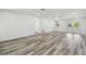 Open-concept living room featuring wood-look floors, neutral walls and natural light at 4608 Deltona Blvd, Spring Hill, FL 34606