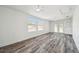 Spacious living room with wood-look flooring, ceiling fans, and access to the outdoors at 4608 Deltona Blvd, Spring Hill, FL 34606