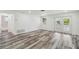 Bright living room with wood-style flooring and access to outdoors and bathroom at 4608 Deltona Blvd, Spring Hill, FL 34606