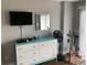 This bedroom features a dresser, mirror, TV, fan, and stationary bicycle at 51 Island Way # 309, Clearwater Beach, FL 33767