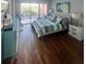 Bright bedroom with a striped comforter and view to a balcony, featuring wood floors at 51 Island Way # 309, Clearwater Beach, FL 33767