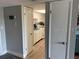 Open view of a kitchen with white cabinets and stainless steel appliances from a hallway at 51 Island Way # 309, Clearwater Beach, FL 33767