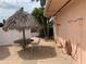 A tiki hut with an outdoor shower and a hose on a brick patio with a view of lush palm trees at 51 Island Way # 309, Clearwater Beach, FL 33767