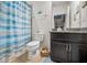 Bathroom featuring tile flooring, dark cabinets and vanity, and shower with blue striped curtain at 5529 White Marlin Ct, New Port Richey, FL 34652