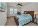 Comfortable bedroom with dark wooden furniture, blue bedding, ceiling fan, and carpeting at 5529 White Marlin Ct, New Port Richey, FL 34652