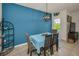 Cozy dining area featuring a vibrant blue accent wall, stylish lighting, and seating for four at 5529 White Marlin Ct, New Port Richey, FL 34652