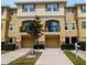 A three-story townhouse featuring dual garages, windows, and a second-story balcony at 5529 White Marlin Ct, New Port Richey, FL 34652