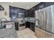 Beautiful kitchen featuring stainless steel appliances, dark cabinetry, and granite countertops at 5529 White Marlin Ct, New Port Richey, FL 34652
