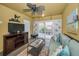 Cozy living room with a ceiling fan, a large tv, a sofa, and sliding glass doors to the patio at 5529 White Marlin Ct, New Port Richey, FL 34652