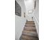 Carpeted staircase leads to the upper level, featuring bright white walls and decorative wall art at 5529 White Marlin Ct, New Port Richey, FL 34652