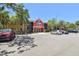 Exterior shot of a well-maintained building with a red accent, parking spaces, and mature landscaping at 5705 Baywater Dr # 5705, Tampa, FL 33615
