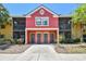 Charming two-story condo with a colorful red exterior, screened-in balconies, and well-maintained landscaping at 5705 Baywater Dr # 5705, Tampa, FL 33615