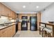 Well-equipped kitchen with wooden cabinets, black appliances, a breakfast bar, and tile flooring at 5705 Baywater Dr # 5705, Tampa, FL 33615