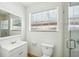 Bright bathroom with tiled shower, white vanity, toilet, and window providing plenty of natural light at 6212 N Grady Ave, Tampa, FL 33614
