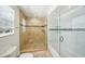 Bathroom with tiled shower and bathtub combo, glass shelving, and marble flooring at 6212 N Grady Ave, Tampa, FL 33614