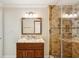 Bathroom with a wooden vanity and marble countertops, with a glass enclosed shower at 6212 N Grady Ave, Tampa, FL 33614
