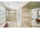 Bathroom with tiled shower, glass shelving, and marble flooring at 6212 N Grady Ave, Tampa, FL 33614