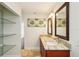 Bathroom with double sinks, granite countertops, and glass shelving at 6212 N Grady Ave, Tampa, FL 33614
