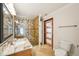 Well-lit bathroom features granite counters, glass enclosed shower with decorative tile surround, and tile floors at 6212 N Grady Ave, Tampa, FL 33614