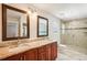 Bathroom with double sinks, granite countertops, wood cabinets, tiled shower, and marble flooring at 6212 N Grady Ave, Tampa, FL 33614