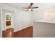 Bedroom features a door to the bathroom, hardwood floors, and a chandelier visible through a large window at 6212 N Grady Ave, Tampa, FL 33614