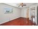 This bedroom features hardwood floors, a ceiling fan, a window, and access to other rooms at 6212 N Grady Ave, Tampa, FL 33614