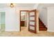 Open doorway reveals the bathroom from the foyer, complemented by staircase and marble tile flooring at 6212 N Grady Ave, Tampa, FL 33614
