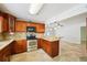 Well-lit kitchen features stone countertops, wood cabinets, and stainless steel appliances at 6212 N Grady Ave, Tampa, FL 33614
