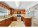 Well-equipped kitchen with wood cabinets, granite countertops, and stainless steel appliances at 6212 N Grady Ave, Tampa, FL 33614